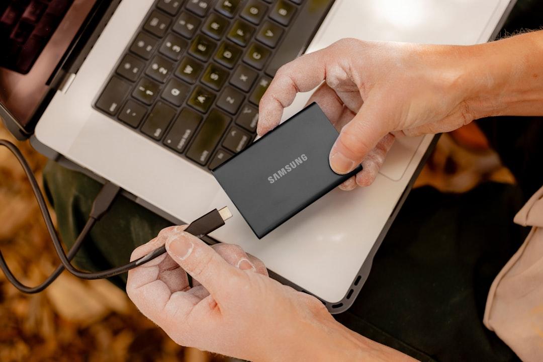 External SSD and hard drive beside a laptop and camera cards