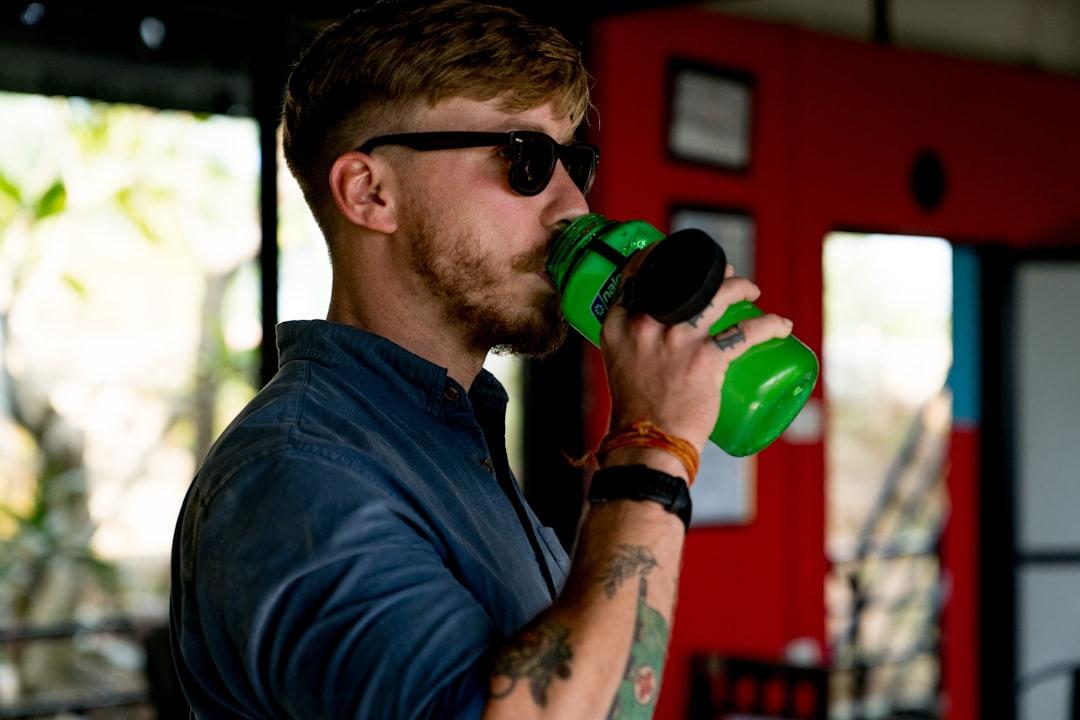 Person drinking a pre-workout style drink before training