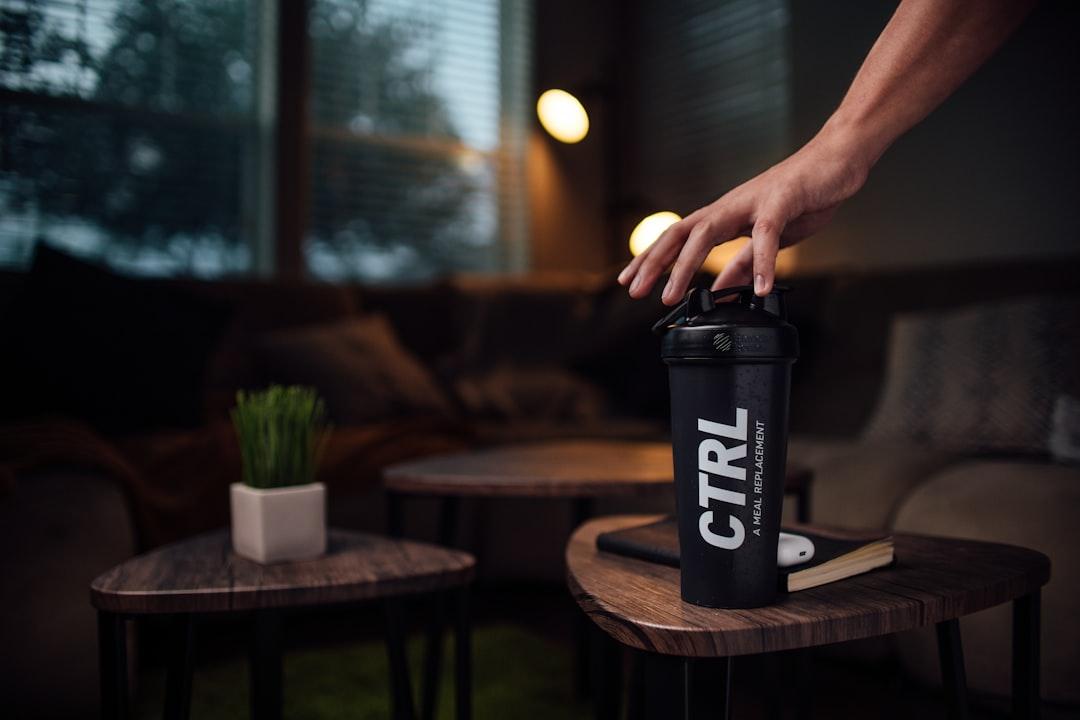 Pre-workout powder, shaker bottle, and gym accessories on a bench